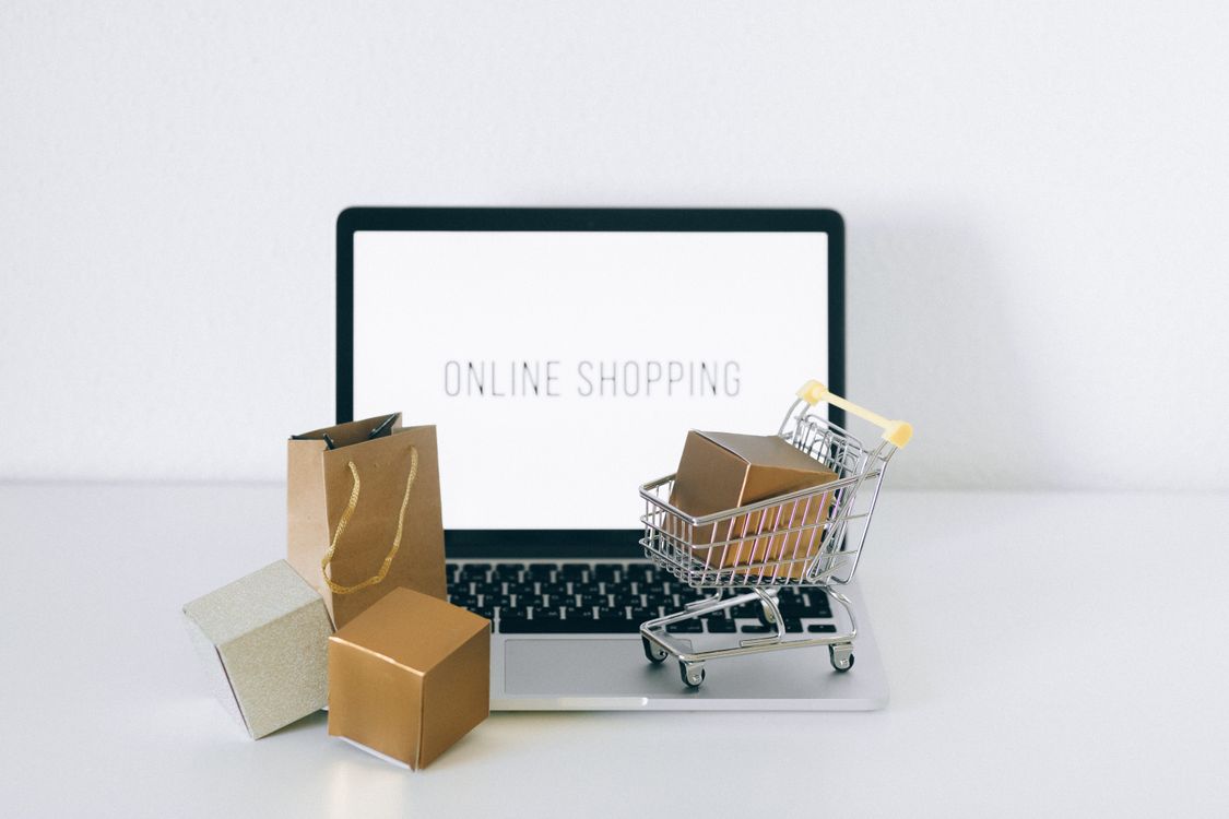 Laptop with parcels and a shopping trolley for online purchase research
